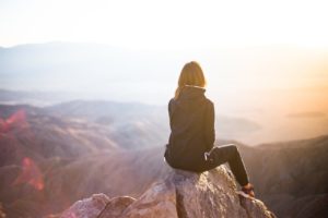 Frau mit Jacke schaut zum Horizont