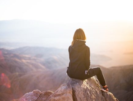 Frau mit Jacke schaut zum Horizont
