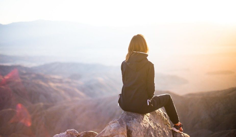 Frau mit Jacke schaut zum Horizont